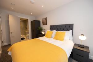 a bedroom with a large yellow bed with yellow pillows at Contemporary 3 Bedrooms Apartment Manchester City in Manchester
