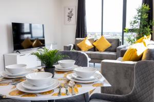 a living room with a table with dishes on it at Contemporary 3 Bedrooms Apartment Manchester City in Manchester