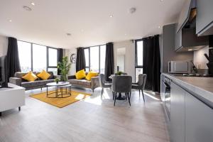 a kitchen and living room with a couch and a table at Contemporary 3 Bedrooms Apartment Manchester City in Manchester