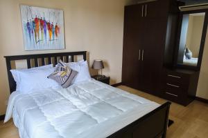 a bedroom with a large bed with white sheets at 22 Premier Place in Accra