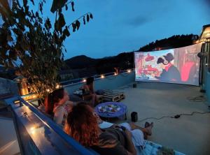 a group of people sitting on a roof watching a movie at Villa Royal in Cetinje