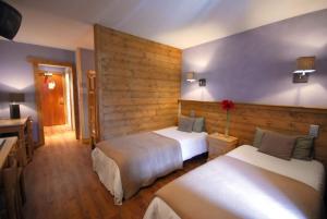 a room with two beds in a hotel room at Hotel Le Monal in Sainte-Foy-Tarentaise