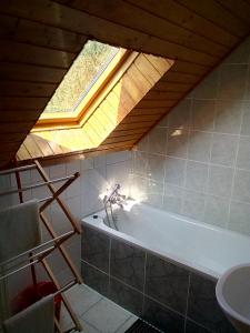a bathroom with a bath tub and a window at F 106 Vendégház in Fertőhomok