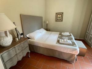 a bedroom with a bed and a dresser with a lamp at Fontepino in Crocemaroggia