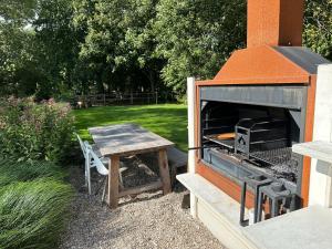 un barbecue all'aperto e un tavolo da picnic in un cortile di The Butchersfarm a Ter Aar