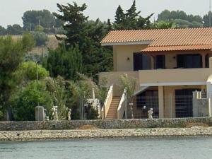 a house sitting on the side of the water at Villa Meri in Torre Lapillo