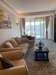a living room with couches and a coffee table at Apartament executive vedere munte Alpin Resort Poiana Brasov in Poiana Brasov