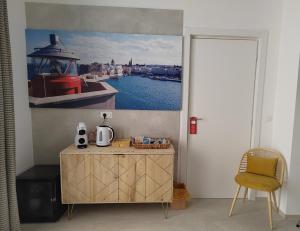 a room with a table and a painting of a boat at Dimore Gilas - Suite Golden in Monopoli