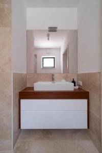 uma casa de banho com um lavatório branco e um espelho. em Weinkeller Röschitz em Roggendorf