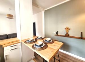 a kitchen with a table with bowls and plates on it at Appartement F3 55m2 à 5' de Paris in Ivry-sur-Seine