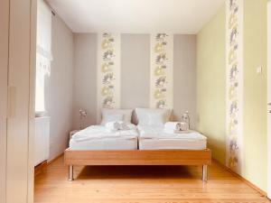 1 dormitorio con 2 camas con sábanas blancas en Ruhig, modern & Nähe Altstadt!, en Meiningen