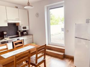 eine Küche mit einem Tisch und einem weißen Kühlschrank in der Unterkunft Ruhig, modern & Nähe Altstadt! in Meiningen