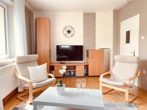 a living room with two chairs and a tv at Ruhig, modern & Nähe Altstadt! in Meiningen