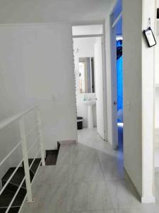 Habitación blanca con escalera y baño. en Bellísima casa para descansar en Ricaurte