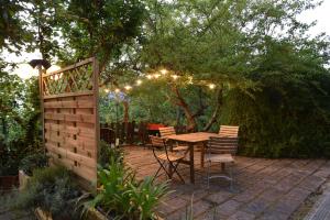 Un patio con mesa, sillas y luces. en Il Filo di Arianna Cottage di Campagna, en Colonnella