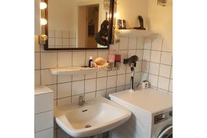 a bathroom with a sink and a washing machine at Private Apartment in Hannover