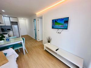 a living room with a desk and a tv on a wall at Torres del Sol Playa de Las Vistas FREE WIFI in Playa de las Americas
