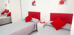 two beds in a white room with red pillows at La Pedrera Font Nova in Peniscola +22 photos