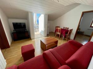 a living room with a red couch and a table at Apartments Hanka in Njivice