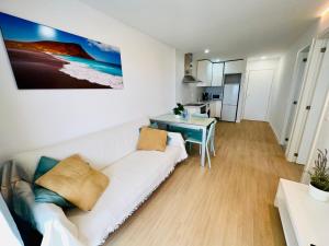 a living room with a white couch and a table at Torres del Sol Playa de Las Vistas FREE WIFI in Playa de las Americas