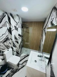 a bathroom with a white toilet and a sink at Torres del Sol Playa de Las Vistas FREE WIFI in Playa de las Americas