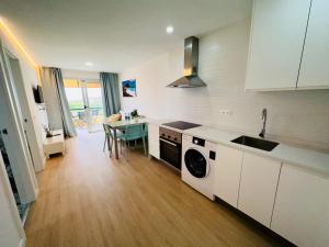 a kitchen with a sink and a table in it at Torres del Sol Playa de Las Vistas FREE WIFI in Playa de las Americas
