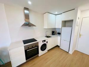 a kitchen with white cabinets and a washer and dryer at Torres del Sol Playa de Las Vistas FREE WIFI in Playa de las Americas