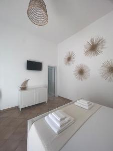 a white room with a bed and three mirrors on the wall at A'mmare Rooms&Apartments Santa Maria di Leuca in Leuca