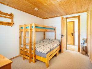 a bedroom with two bunk beds and a wooden ceiling at Chalet am Sunne-Egge auf Axalp bei Brienz in Axalp