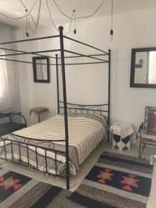 a bedroom with a black metal canopy bed at Maison Avec Jardin Garage in La Marsa