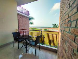 een balkon met 2 stoelen en een tafel met uitzicht bij DERA Resort & Spa in Cox's Bazar