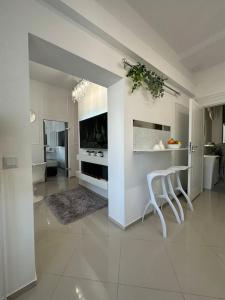 a living room with two white chairs and a kitchen at Salt INN Apartments No 2 - jacuzzi in Wieliczka