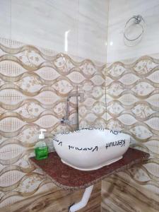 a bathroom with a sink with writing on the wall at Kurchi Homestay in Ghātsīla