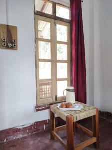 a table with a window and some fruit on it at Kurchi Homestay in Andipur