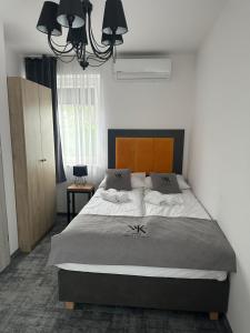 Un dormitorio con una cama grande y una lámpara de araña. en Willa Krzemień, en Sandomierz