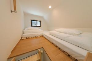two beds in a small room with a window at Nakano Five in Tokyo