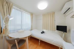 a room with a bed and a table and a window at Nakano Five in Tokyo
