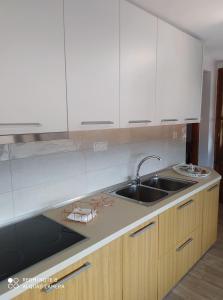 a kitchen with white cabinets and a sink at Vasilis house in Kallirákhi