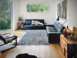 een woonkamer met een zwarte bank en een tapijt bij Cortina Apartment in Otari