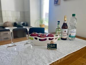 una mesa con dos copas de vino y un tazón de manzanas en gemütliches Appartement - 20 min bis Dresden, en Leppersdorf