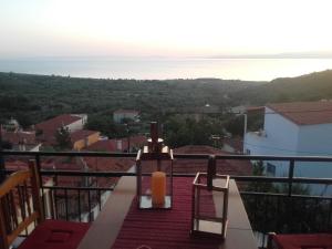 a candle on a balcony with a view of the ocean at Vasilis house in Kallirákhi