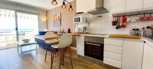 a kitchen with white cabinets and a table and a counter at Ca Cristina "Scorpio" Puerto Rico in Puerto Rico de Gran Canaria