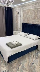 a bedroom with a large bed with towels on it at VIP апартаменты однокомнатная квартира in Uralsk