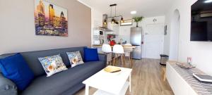 a living room with a blue couch and a kitchen at Ca Cristina "Scorpio" Puerto Rico in Puerto Rico de Gran Canaria