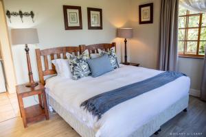 a bedroom with a large white bed with blue pillows at Old Rearsby in Mooirivier