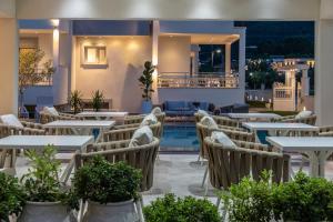 un restaurante con mesas y sillas y una piscina en Sole Mare en Chrysi Ammoudia