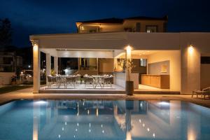 a villa with a swimming pool at night at Sole Mare in Chrysi Ammoudia