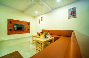 Zimmer mit Sofa, Tisch und TV in der Unterkunft UMBER 6BHK VILLA ALIBAUG in Alibag