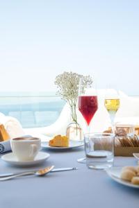 una mesa con dos copas de vino y comida en Relais La Ghinghetta en Portoscuso