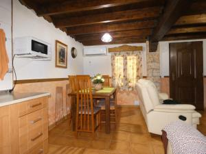 a kitchen with a table and a couch and a chair at Casa Rural La Encina in Villaverde de Guadalimar